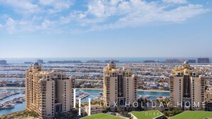 A high-rise hotel with multiple towers, marina, and a view of the cityscape. - LUX Iconic Views at Palm Tower Suite 7 (Dubai)