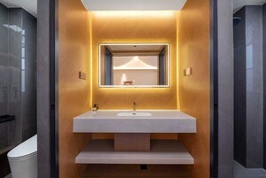 Un baño moderno con un espejo grande, un lavamanos blanco y un mueble de tocador de madera.