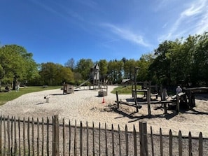A playground with a slide, climbing structures, and a sandpit. - Luxury Cannenburch Deluxe with Hot Tub & Sauna. Enjoy a hot tub, cozy outdoor space, and fully equipped kitchen. (Lieren)