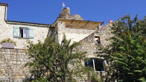 Un bâtiment en pierre avec un petit balcon et un drapeau au sommet.