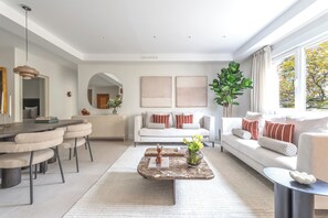 A modern living room with a dining area, a sofa set, and a large window with a view. - Bright and spacious in Chamberí (Madrid)