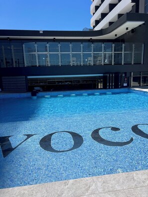 Una piscina al aire libre, una piscina climatizada