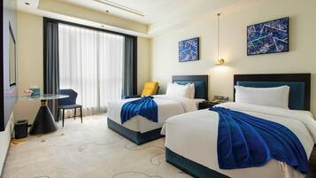 Cubrecamas, espacio para trabajar con laptop y cortinas blackout