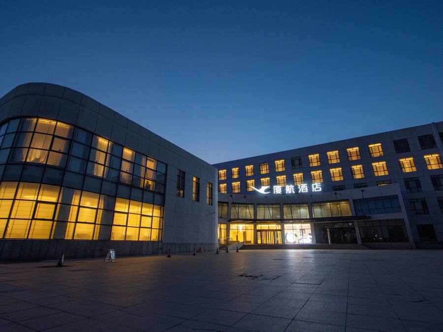 A modern building with large windows and a well-lit entrance.