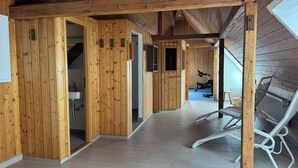 A wooden interior with a hallway leading to a gym area. - DORMERO Hotel Crailsheim (Crailsheim)