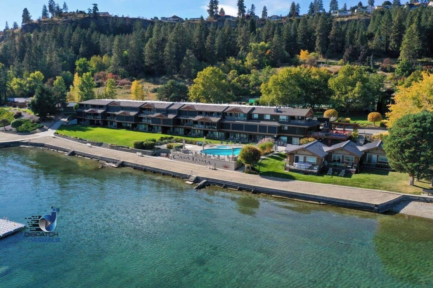 Aerial view of the resort's lush waterfront, showcasing the green landscape and buildings along the shore.