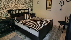 Ein Schlafzimmer mit Bett, Nachttisch, Kommode und Stuhl.