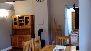 Un comedor con mobiliario de madera, una lámpara de araña y un aparador de madera con puertas de vidrio.