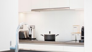 Eine moderne Küche mit einer Edelstahl-Dunstabzugshaube, einem Toaster, einem Wasserkocher und einem Topf auf der Arbeitsfläche.