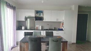 Eine moderne Küche mit weißen Schränken, einer Mikrowelle, einem Toaster und einem Spülbecken.
