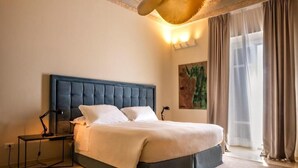 Een slaapkamer met een groot bed, nachtkastje, lamp en een plafondlamp.