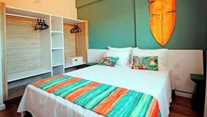 Une chambre à coucher avec un lit, une armoire et un grand tableau abstrait accroché au mur.