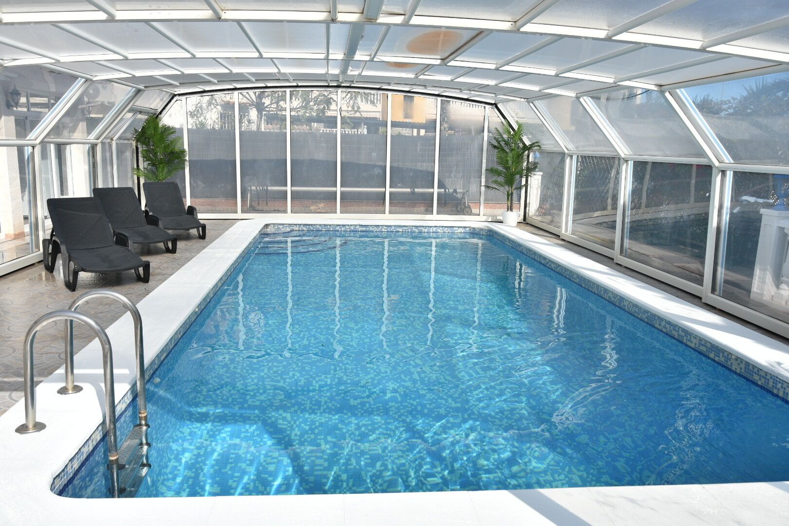 Una piscina cubierta, una piscina al aire libre