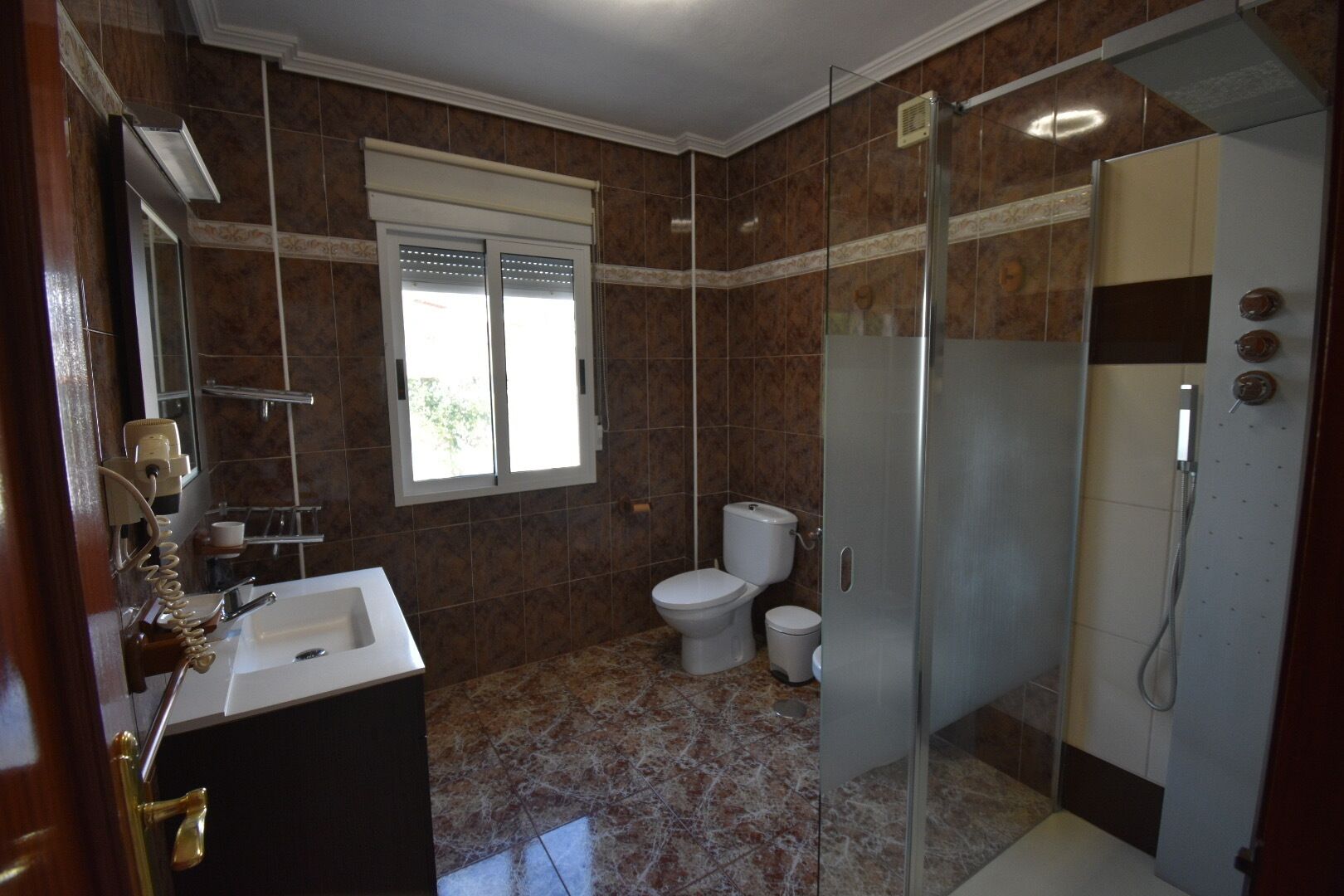 Un baño con ducha, inodoro y lavamanos.