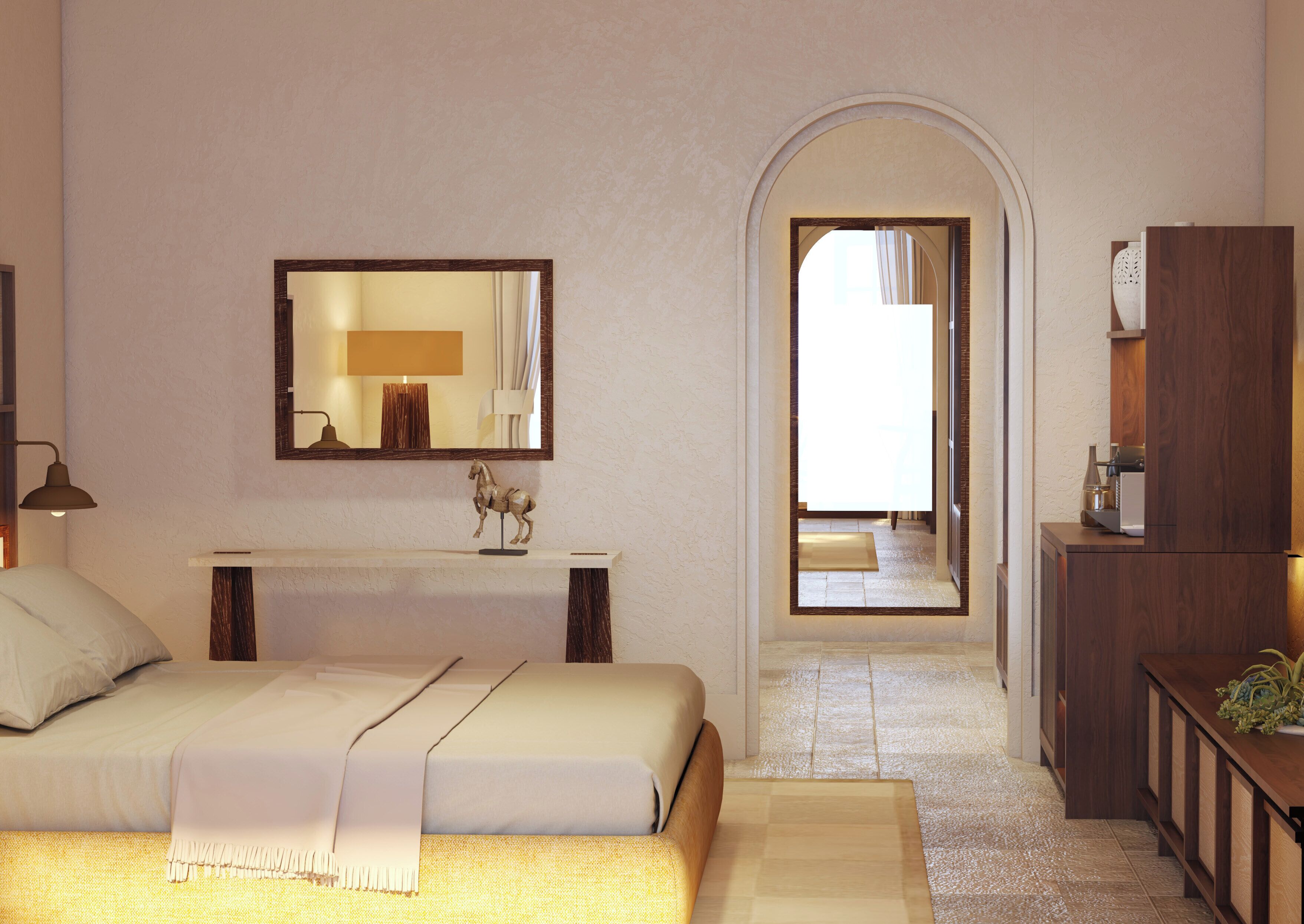 A bedroom with a bed, a bedside lamp, a mirror, a small statue, a console table, and a wooden cabinet.
