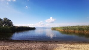 Un río tranquilo con orillas de arena y vegetación densa a ambos lados.