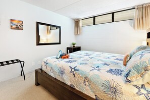 Ein Schlafzimmer mit einem Bett, einem Nachttisch, einem Spiegel, einem Bild an der Wand und einem Fenster mit Vorhängen.