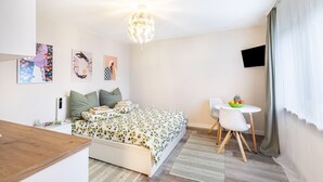 Ein Schlafzimmer mit einem Bett, einem Nachttisch und einem kleinen Schreibtisch mit Stuhl.