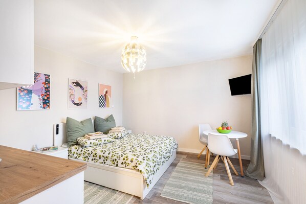 Une chambre à coucher comprenant un lit, une table de chevet et un petit bureau avec une chaise.