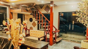A modern interior with a staircase, a sofa, and decorative elements. - Sunoraa Luxury Hotel And Spa (Mussoorie)