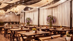 A restaurant with multiple tables and chairs, draped curtains, and chandeliers. - Sunoraa Luxury Hotel And Spa (Mussoorie)