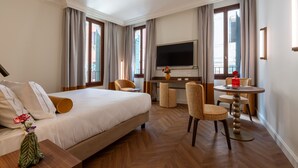 A hotel room with a bed, a desk, a TV, and a seating area. - Hotel San Samuele (Venice)