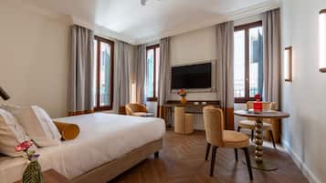 Una habitación de hotel con cama, escritorio, televisor y zona de estar.