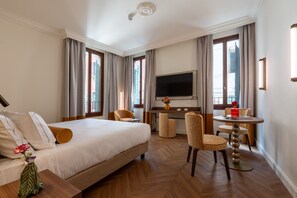 A hotel room with a bed, a desk, a TV, and a seating area. - Hotel San Samuele (Venice)