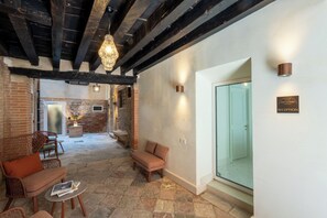 A reception area with a stone floor, wooden furniture, and a glass door leading to the reception. - Hotel San Samuele (Venice)