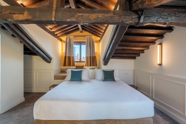 A bedroom with a large bed, a wooden ceiling, and a window with curtains. - Hotel San Samuele (Venice)