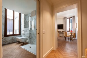 Un bagno moderno con box doccia in vetro, un water e uno schienale in marmo.