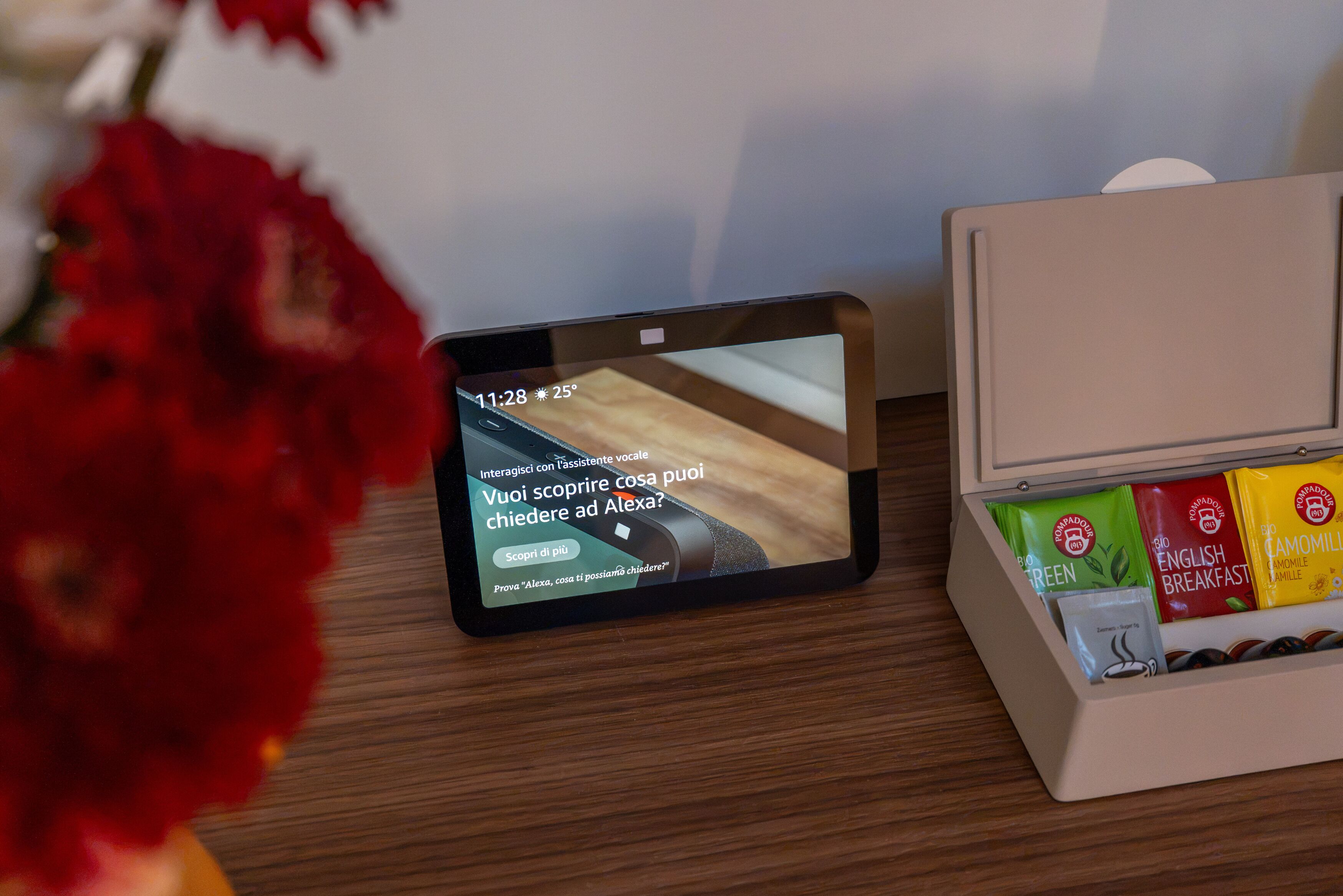 A tablet displaying a message in Italian, a wooden surface, and a box with coffee bags.