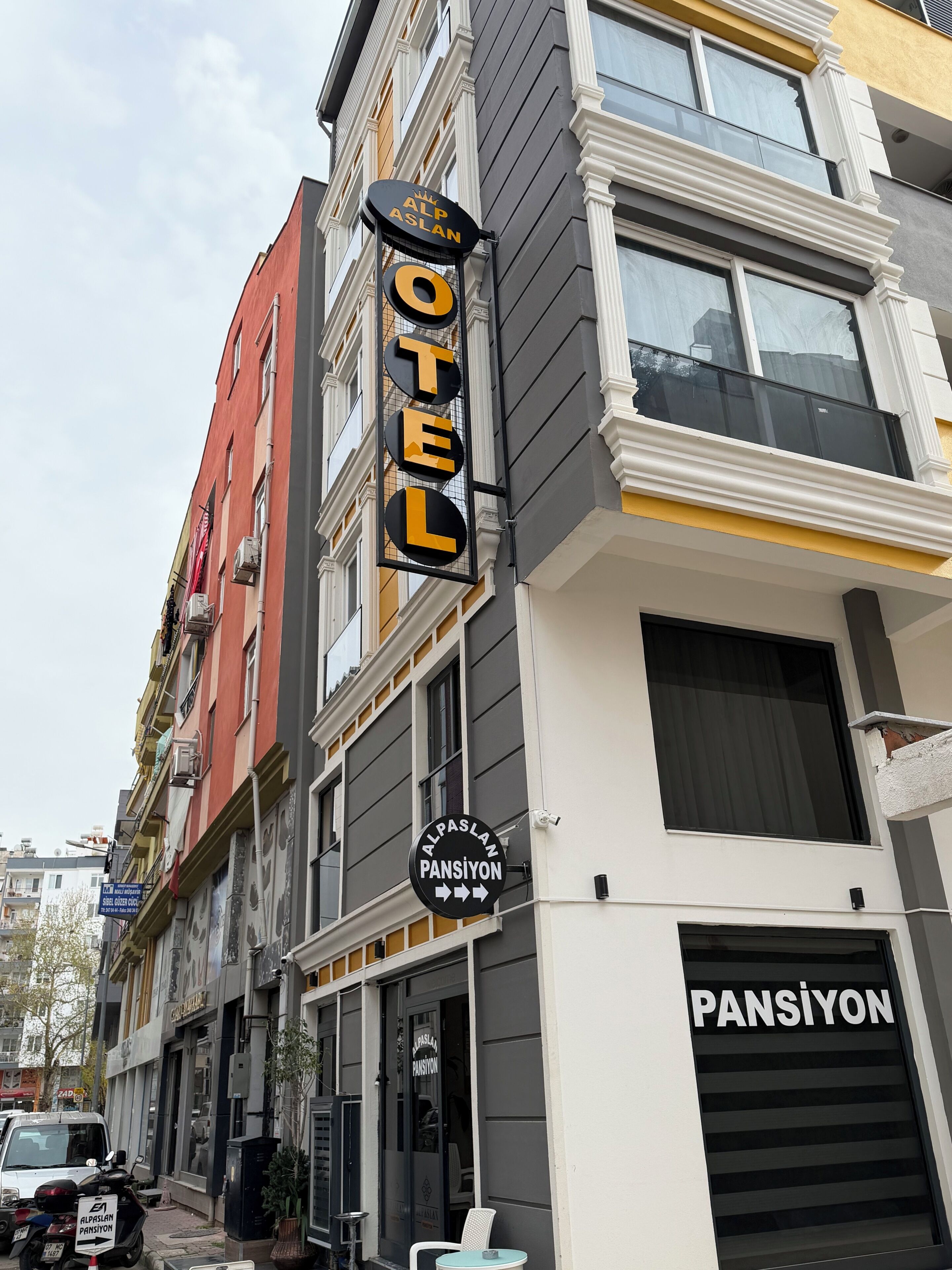 A hotel sign with 'ALP ASLAN HOTEL' and 'PANSIYON' indicating the hotel's name and location.