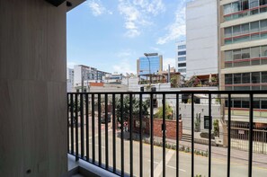 A balcony with a view of a city street, buildings, and a clear sky. - w Tranquil 2BR w Balcony in Miraflores (Lima)
