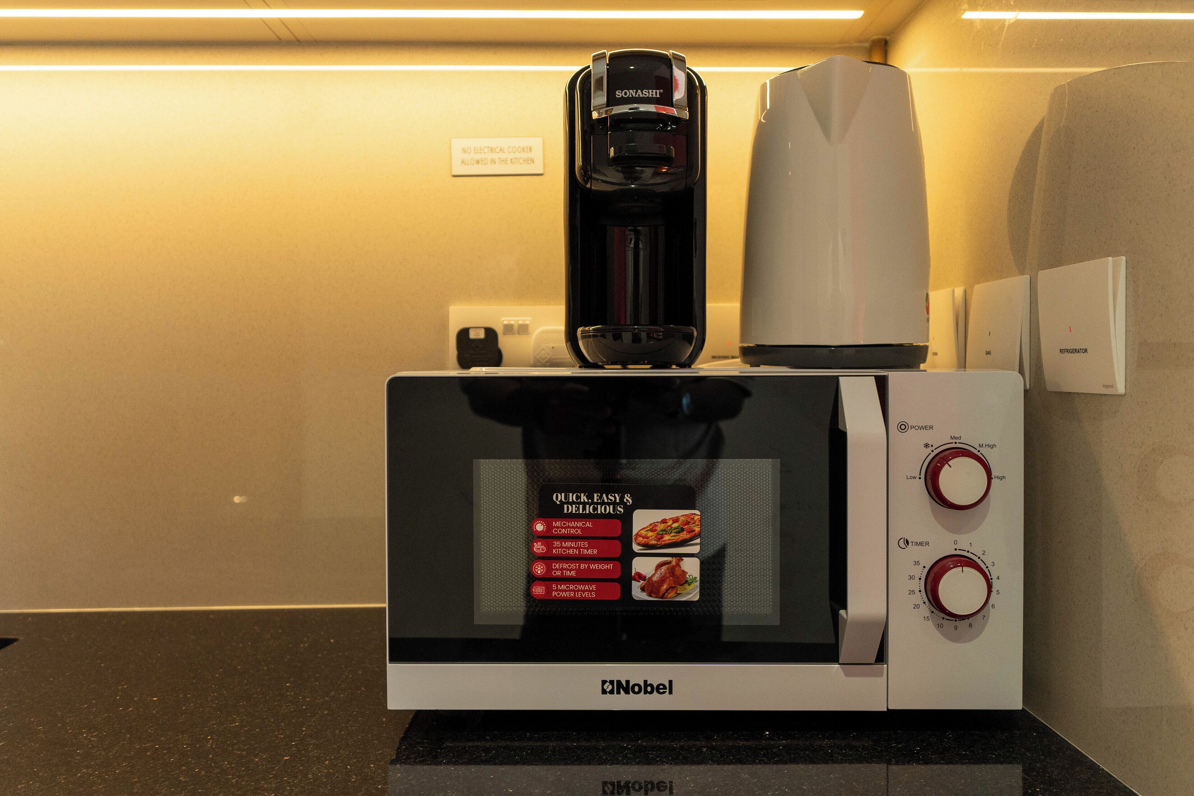 A microwave with a coffee maker on top, a timer, and a power button.