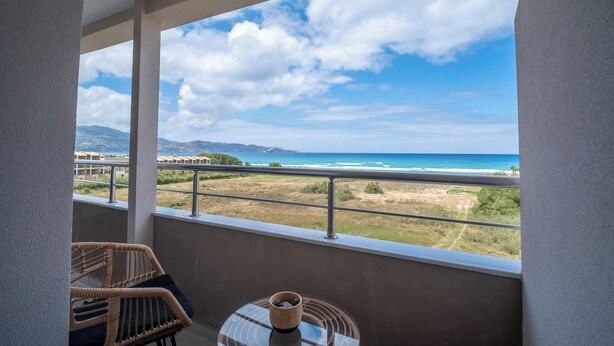 Un balcon avec vue sur la plage et les montagnes.