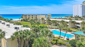 Un resort con piscina, palmeras y vista al océano.