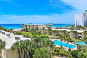 Ein Resort mit Pool, Palmen und Blick auf den Ozean.