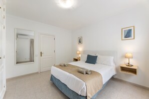 A hotel room with a large bed, two bedside tables with lamps, a mirror, and a framed picture on the wall. - Casa la Geria - 3 (2) by Escape Home (Puerto del Carmen)