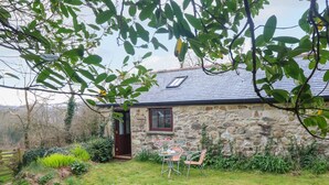 A stone house with a small garden, a wooden door, and a window. - Little Tregarrick (Helston)