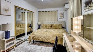 A bedroom with a large bed, a mirror, a vanity with lights, and a chandelier. - Walk to Public Transit! Pet-friendly Lodi Apt (Lodi)