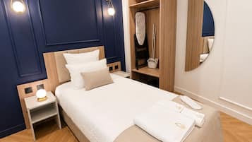 Et pænt indrettet hotelværelse med seng, sengebord og indbygget garderobeskab.
