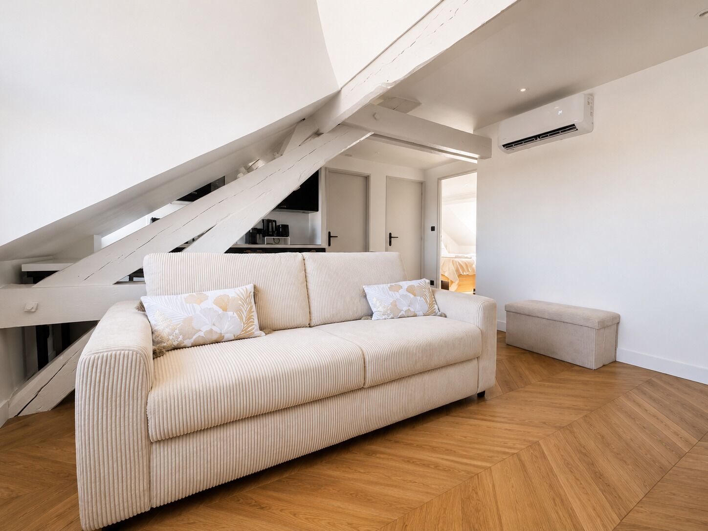Una sala de estar moderna con un sofá, un banco y una escalera.
