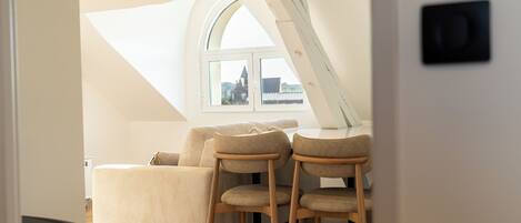 Un dormitorio con una cama, dos sillas, una ventana y una puerta.