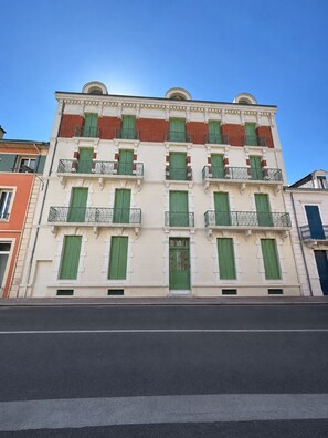 A multi-story building with balconies, a central entrance, and a clear sky. - The Originals Residence, Les Sources Callou, Vichy (Vichy)