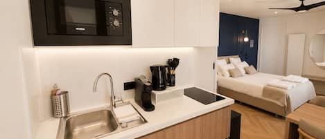 A modern kitchen with a built-in microwave, a sink, and a coffee maker.