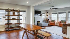 A spacious living room with a wooden coffee table, a bookshelf, a fireplace, and a seating area with two sofas. - 1 Mi to Hermann Park! Updated Apt w/ Parking Spot (Houston)