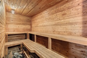 Un sauna avec des murs et des bancs en bois.