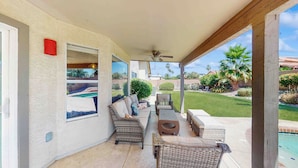A covered patio area with wicker furniture, a ceiling fan, and a view of a swimming pool and garden. - Private Pool, Yard & Pool Table! 'avondale Abode' (Avondale)