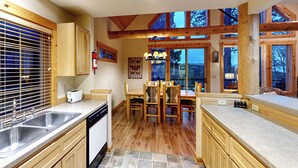 Un'ampia cucina con mobili in legno, una grande isola e un'area pranzo con sedie.